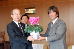 シクラメン鉢を手に記念撮影をする二井知事と木村部会長