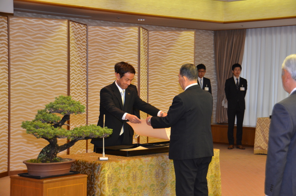 受賞者に勲記等を伝達する村岡知事の写真