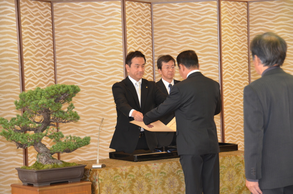 叙勲を伝達する村岡知事の写真