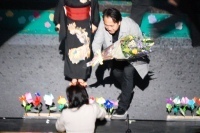 観客から花束を受け取る陣内さんの画像