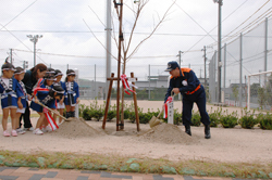 記念植樹を行う西村副知事と子どもたち