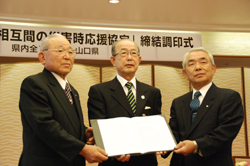 市長会会長の井川下松市長（左）、町村会会長の古木和木町長（右）と協定書を交わした二井知事