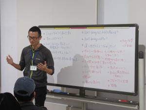 ホワイトボードの前で語る講師