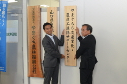 看板を掲出する村岡知事と堀理事長の写真
