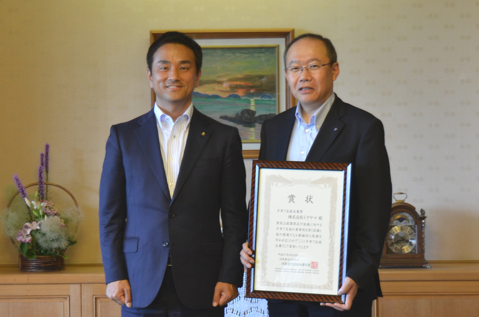 表彰を受けた株式会社トクヤマの横田社長と記念撮影する村岡知事