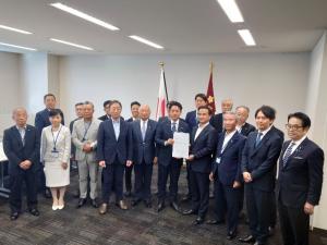 小泉防衛大臣に要望書を渡した後、記念撮影をする村岡知事の写真