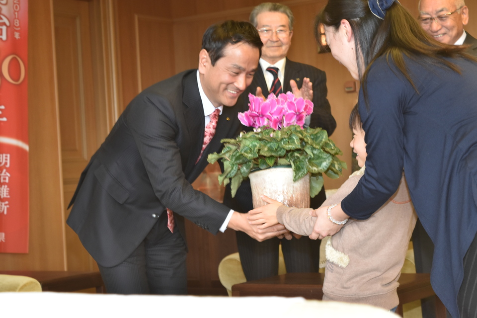シクラメンの鉢を受け取る村岡知事の写真