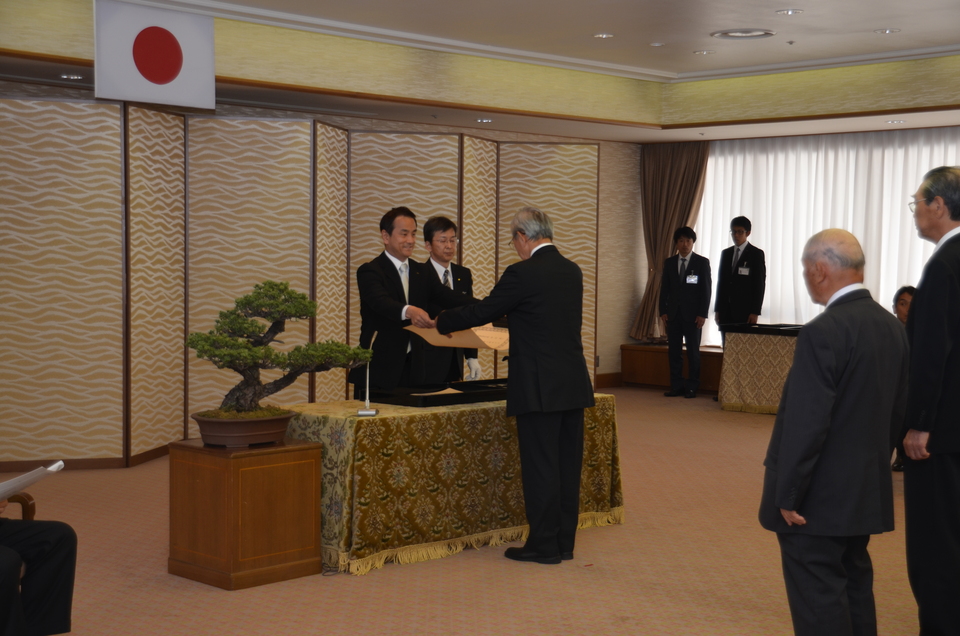 勲記と勲章を手渡す村岡知事の写真