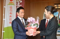 シクラメンを受け取る村岡知事の写真