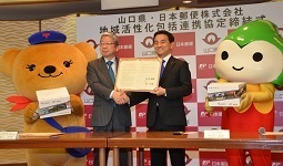協定締結式で握手する村岡知事の写真