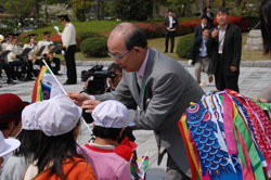 こいのぼりを子どもたちに手渡す二井知事