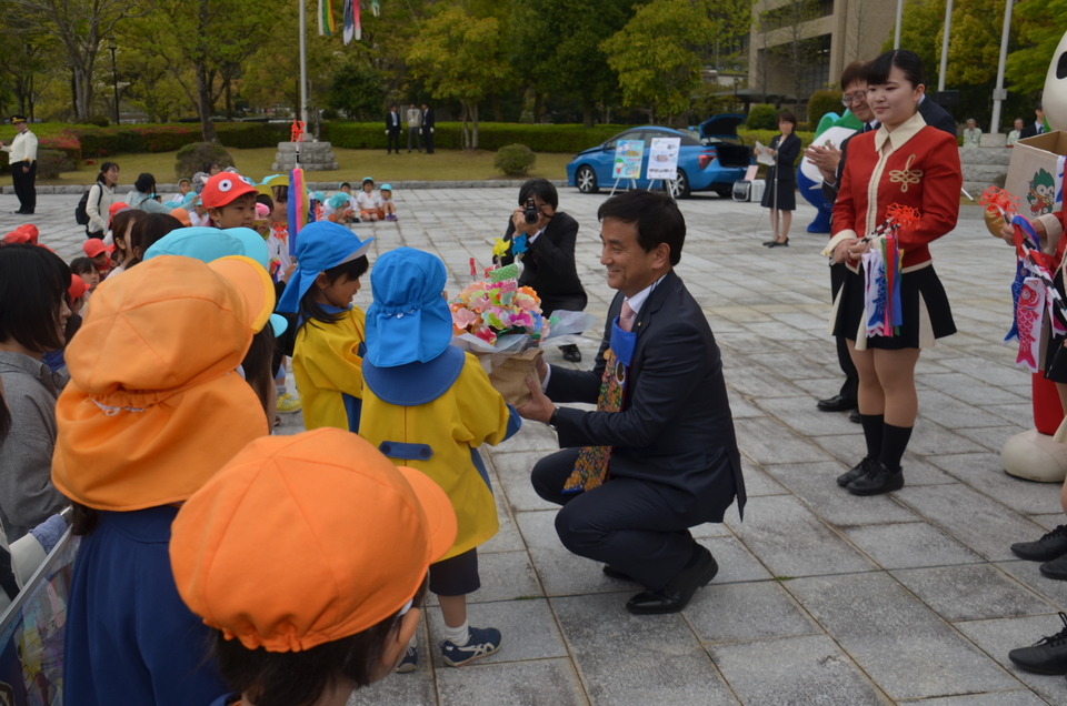 園児とプレゼントを交換する村岡知事の写真