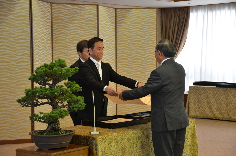 勲記を伝達する村岡知事の写真