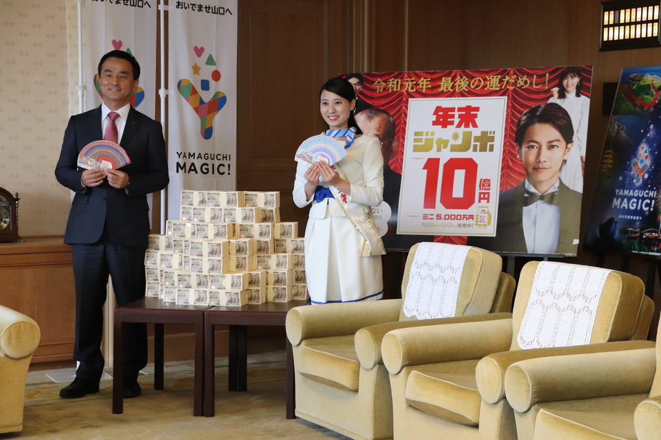 宝くじ「幸運の女神」と記念撮影する村岡知事の写真