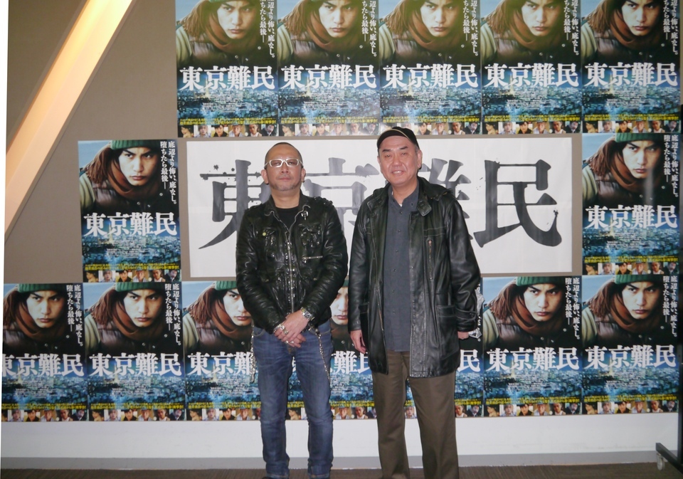 映画館のポスターをバックに記念撮影。左から福澤さん、佐々部さん。の画像