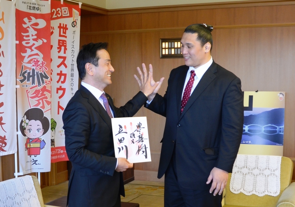 立田川さんと村岡知事が手の大きさを比べている様子