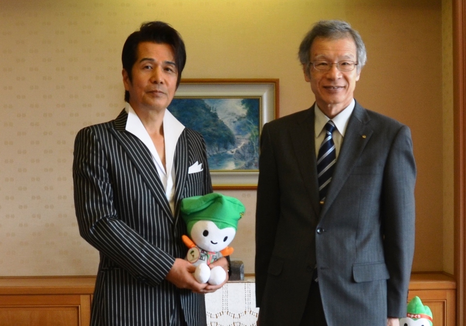 スカウトちょるるを抱いて記念撮影する山川さんと藤部副知事