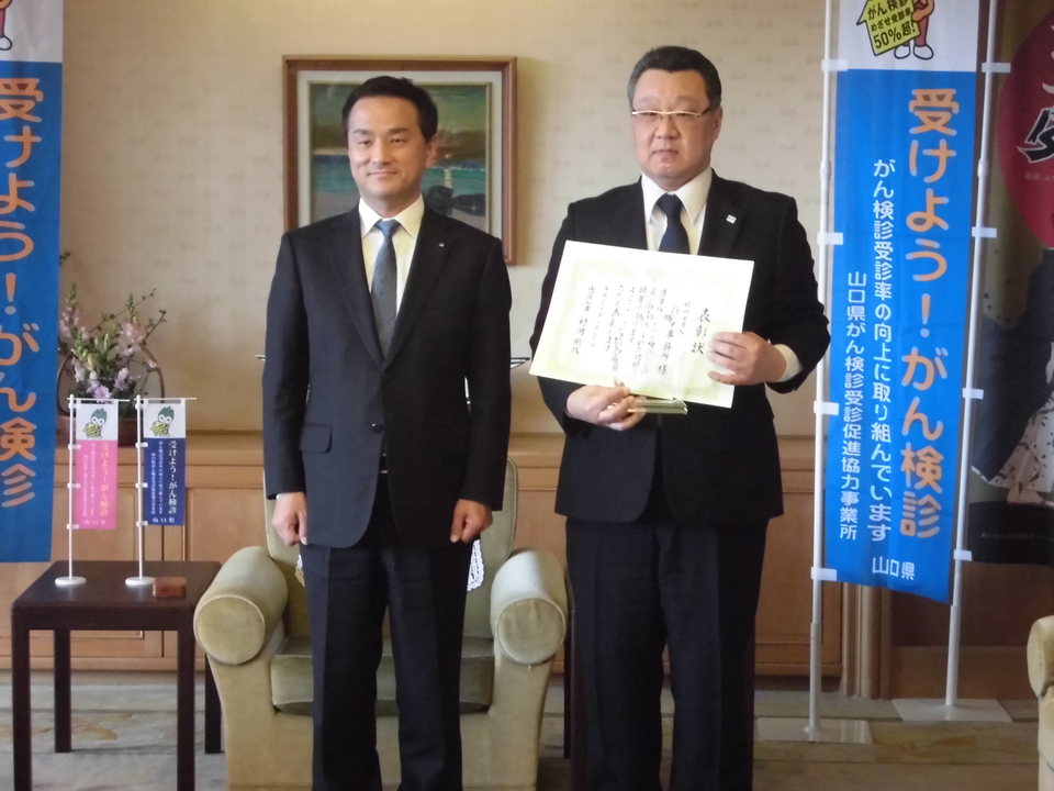表彰式の状況（左から、村岡県知事、税理士法人行本事務所　神崎所長）の画像
