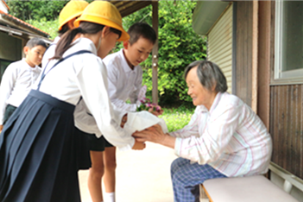 校区内で一人暮らしをされている高齢者を児童と保護者、教職員が訪ね、メッセージの付いたお花を届ける「フラワーデー」を行いました